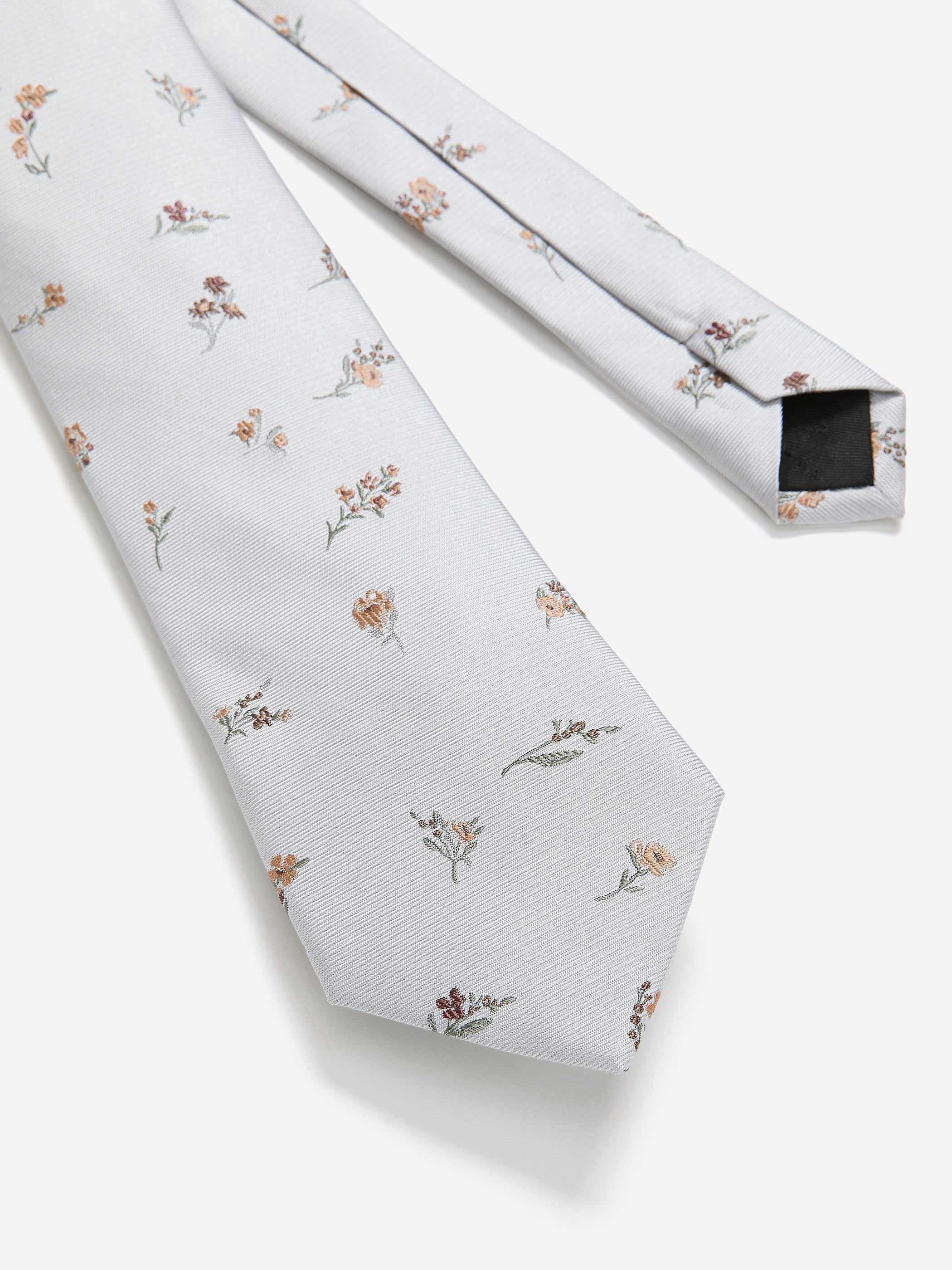 Adoptez un style élégant grâce à cette cravate à coupe régulière en soie grise ornée d'un superbe imprimé fleuri.